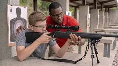 One-on-one professional marksmanship instruction and rifle shooting fundamentals at an outdoor firing range.
