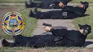 Law Enforcement trainees laying on the ground on their backs firing handguns at the shooting range.